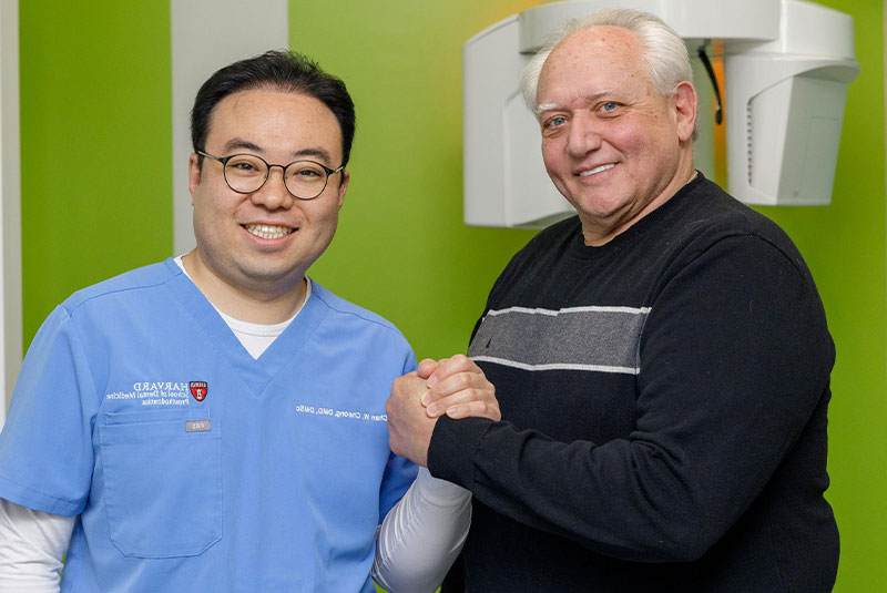 doctor and patient smiling together within the dental practice after patient dental procedure